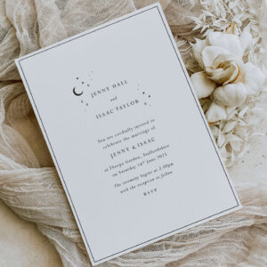 starry skies - simple modern celestial wedding invitation shown with a cream flower
