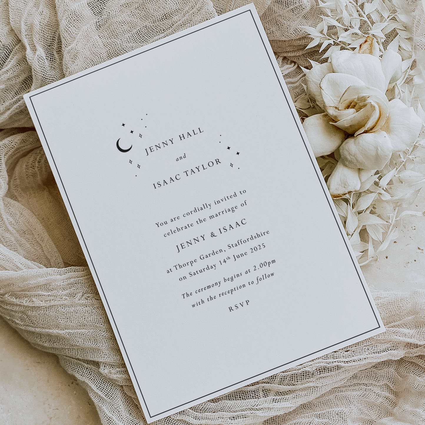 starry skies - simple modern celestial wedding invitation shown with a cream flower